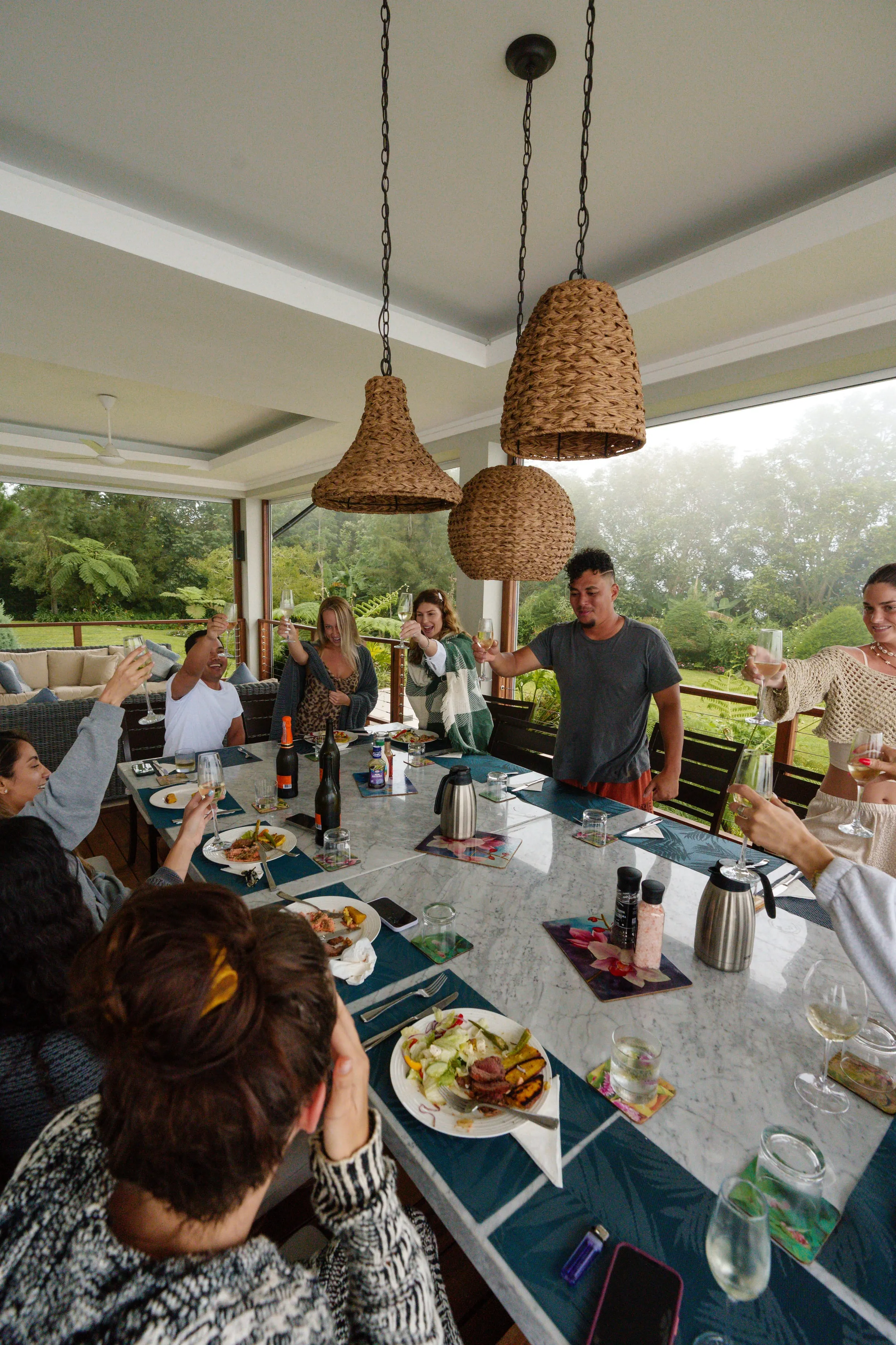 Guests raising a toast around a long table in an open-air villa